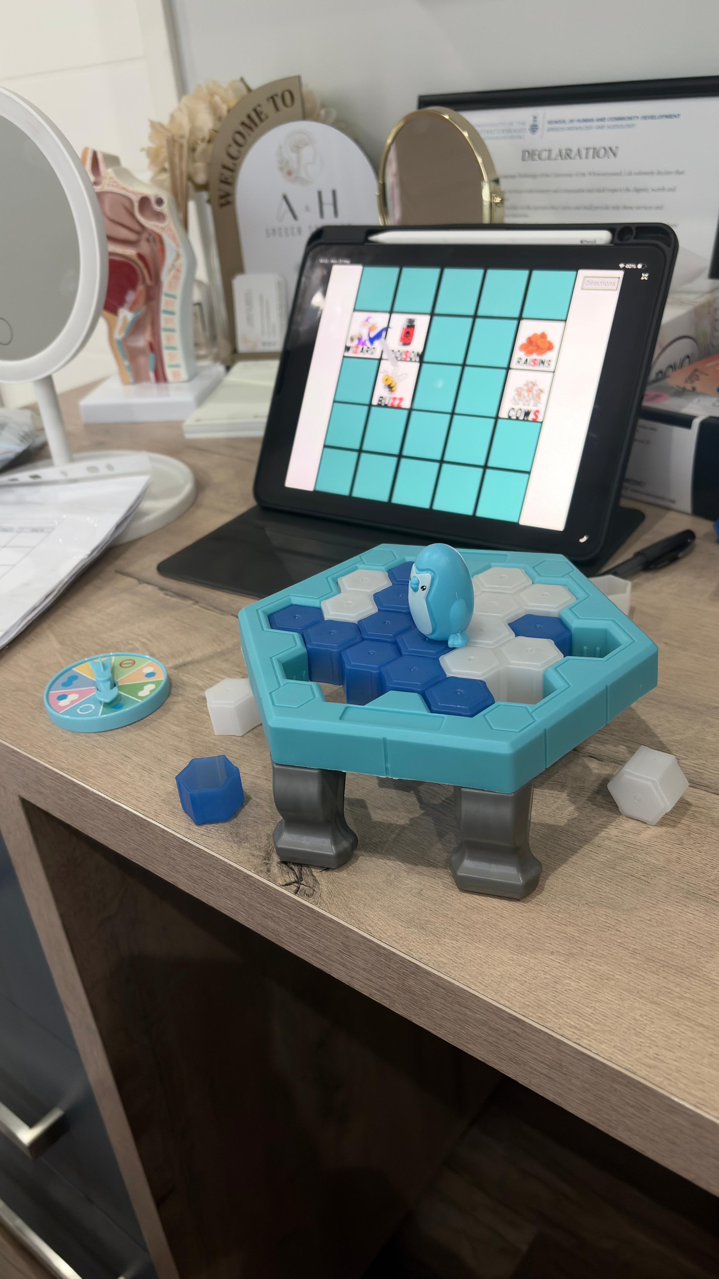 Speech therapy desk with games, tablet activities, and practice materials