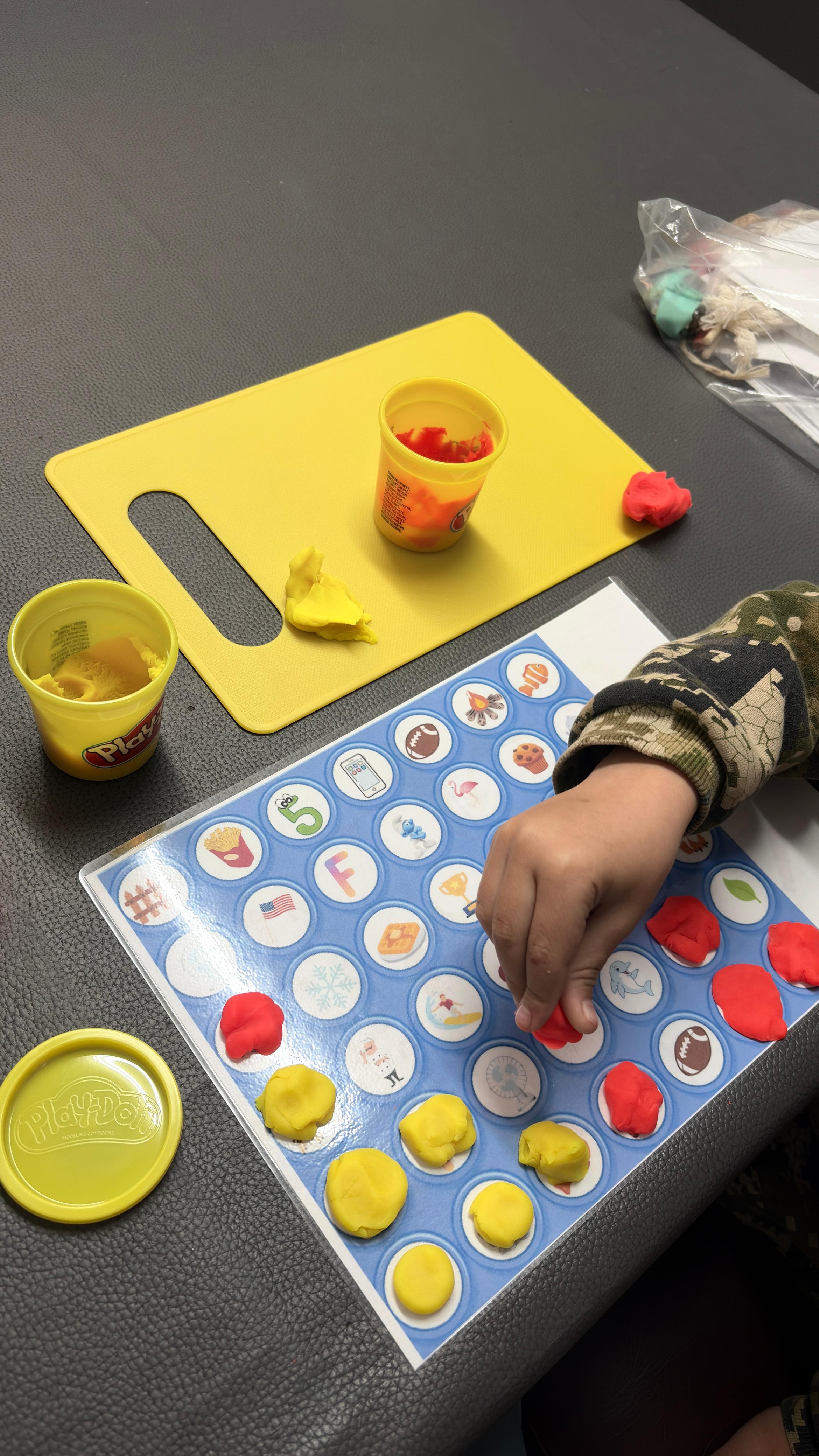 Play-Doh activity on a laminated picture grid during a therapy session